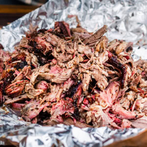 Close up of shredded smoked lamb shoulder showing juicy texture and smoky crust