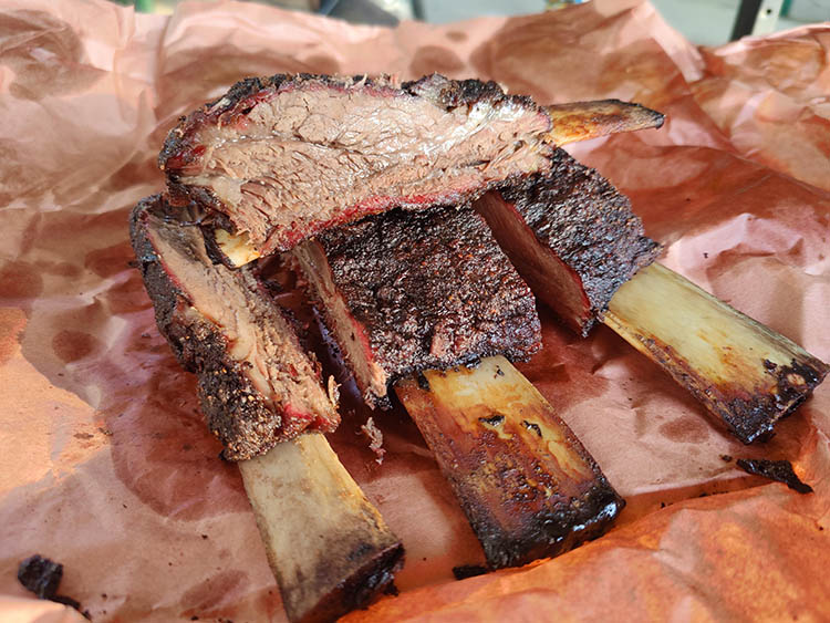 smoked beef ribs on a sheet of pink butcher paper