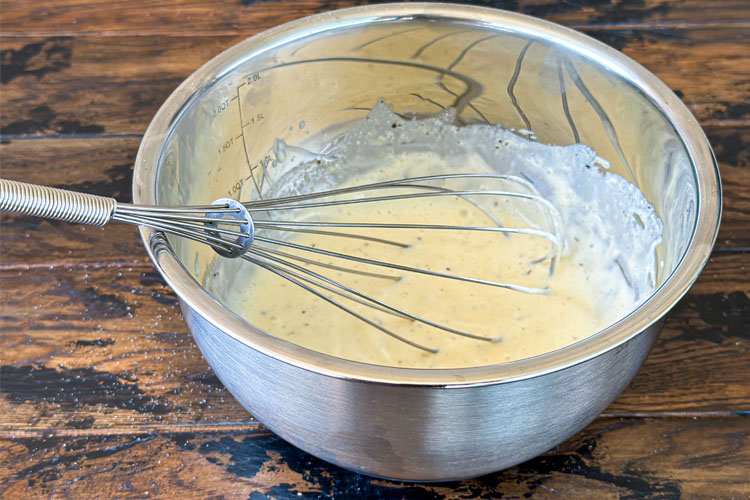 coleslaw dressing in a stainless bowl with a wisk