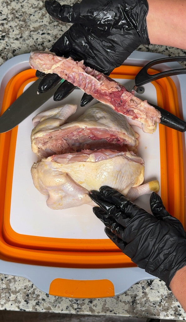 a raw chicken with the backbone removed