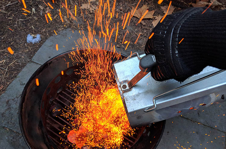 pouring hot coals wearing grill heat aid bbq gloves 