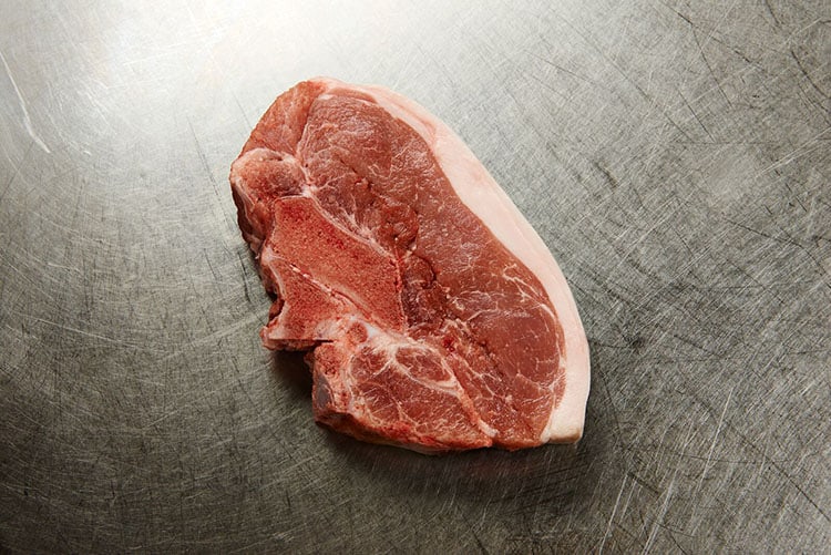 raw sirloin chop on a metal surface