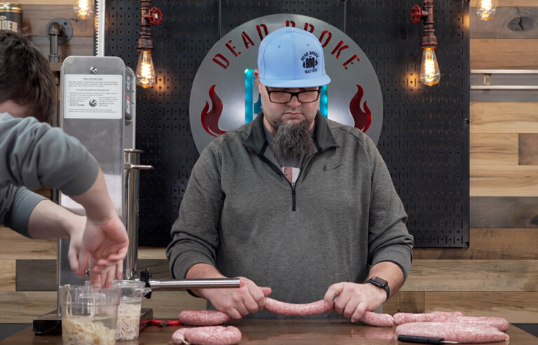 Man making sausage using a sausage stuffer machine