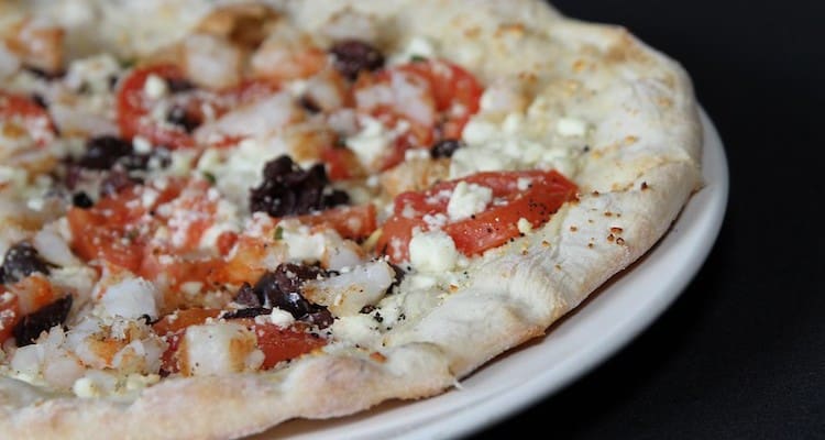 Greek style pizza type with tomatoes, feta and olives