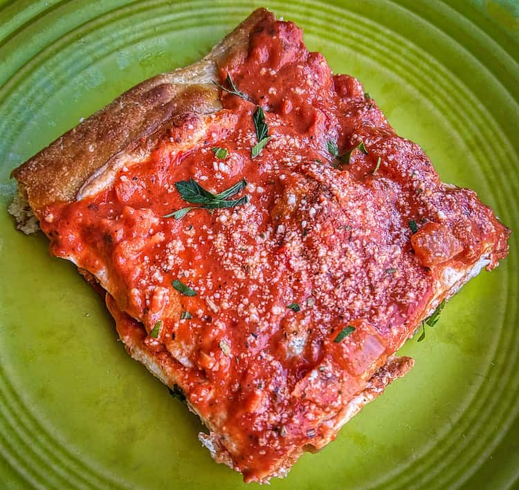 Rectangular piece of crust with tomato sauce