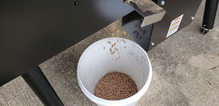 wood pellets falling into a plastic bucket