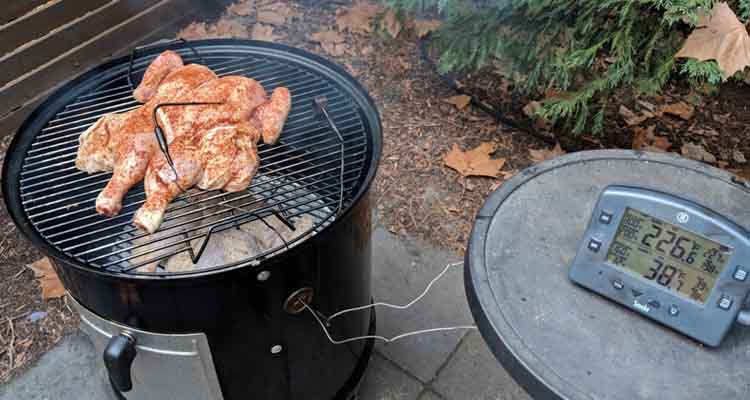 chicken cooking on a charcoal smoker