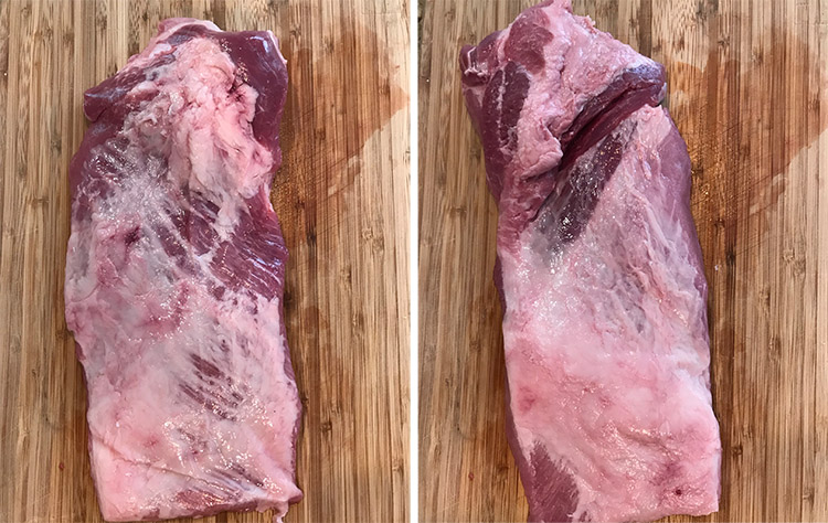 raw pork brisket cut on a wooden board
