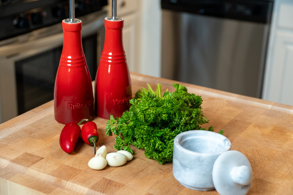 chimichurri ingredients laid out on a wooden chopping board