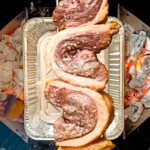 top view of picanha steaks on rotisserie over hot charcoal