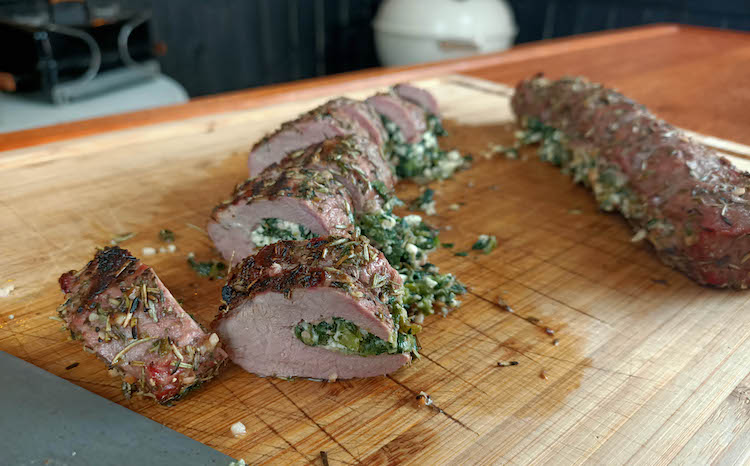 grilled stuffed lamb backstraps on a wooden board