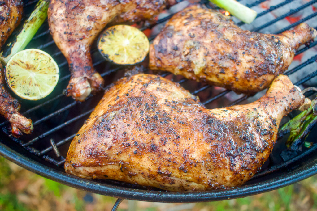 a cooked quarter leg jerk chicke on the grill
