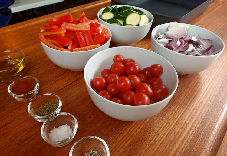 chopped bell peppers, zucchinis, onions and raw tomatoes in bowls