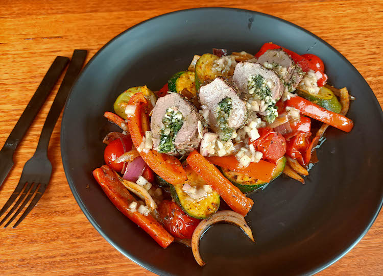 stuffed lamb backstraps on a bed of roasted vegetables