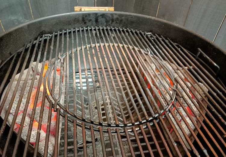 weber kettle with two charcoal baskets on each side of the grill 