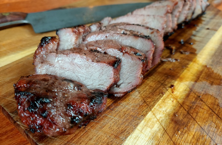 sliced pork strips on a wooden board
