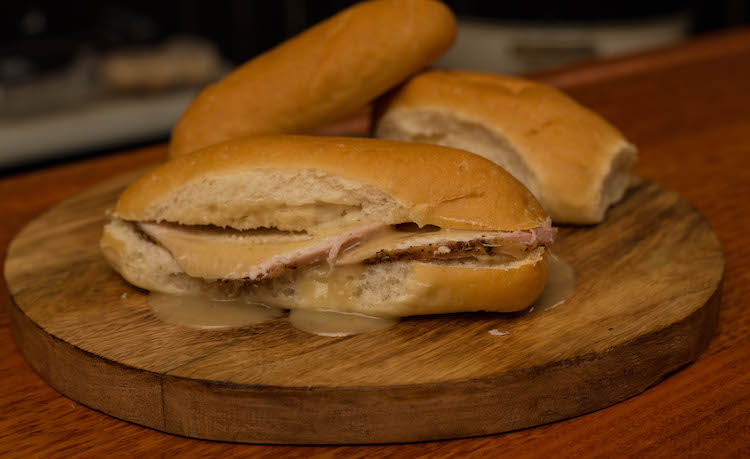 slices of chicken on a bread roll with gravy