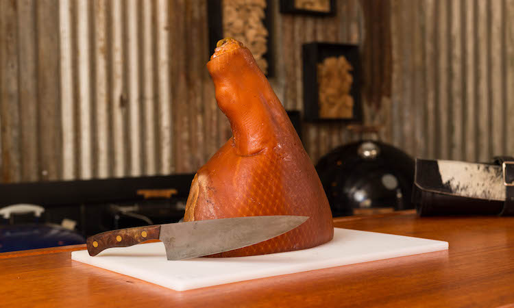 a half leg of ham on a plastic chopping board