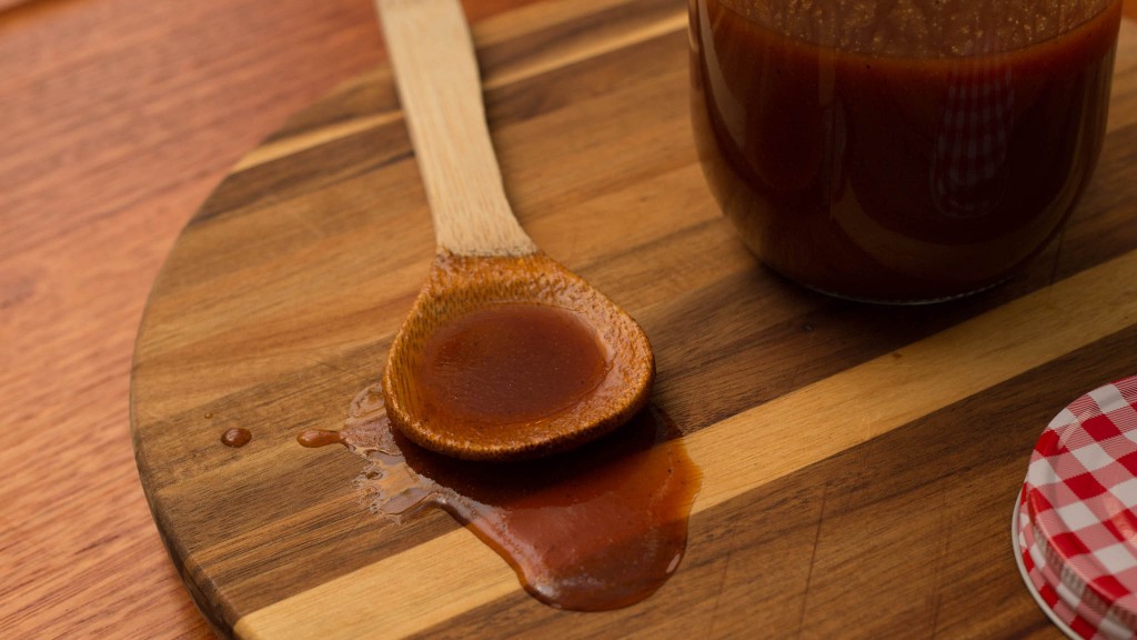 a wooden board with wooden spoon and spilled bbq sause