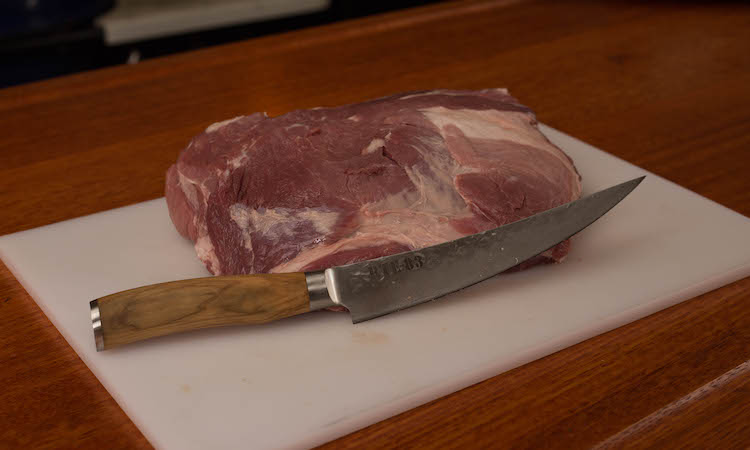 raw pork collar on a plastic board