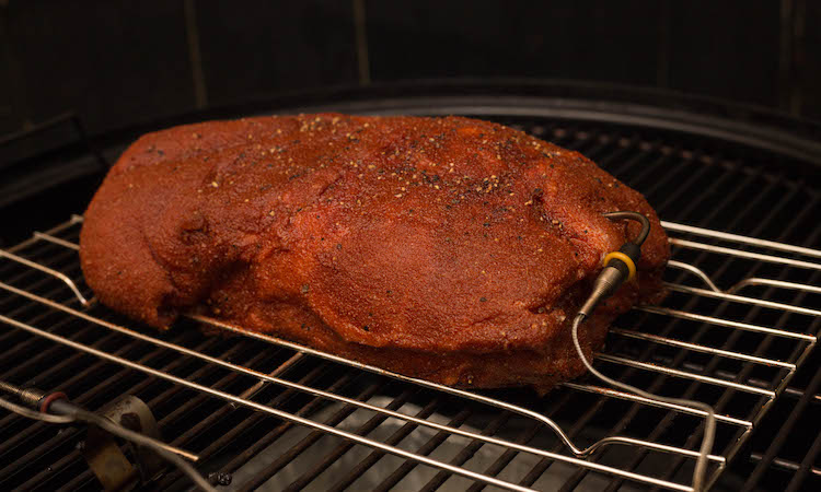 pork butt with a temperature probe on a smoker
