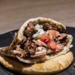 chicken and lamb gyro served on a dark plate