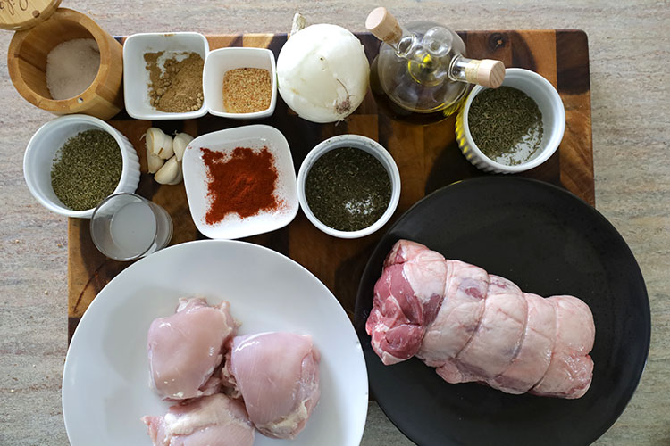 chicken thighs, lamb shoulder and spices on a wooden board