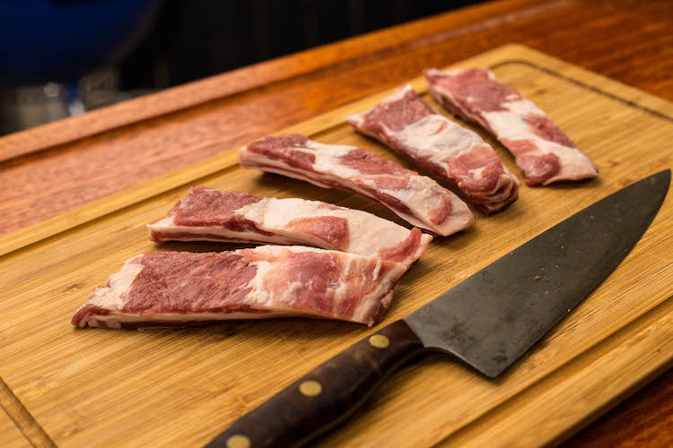 raw lamb ribs on a wooden board