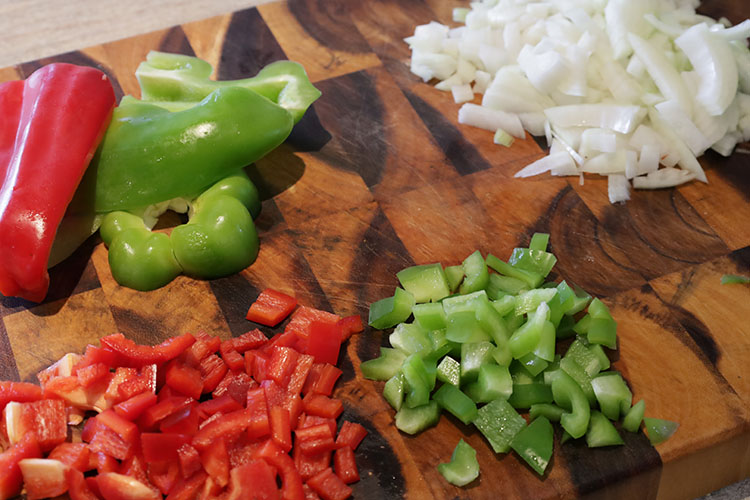 sliced bell peppers and onion on a wooden board