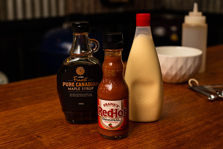 maple syrup, hot sauce and Kewpie mayonnaise bottles on a wooden table
