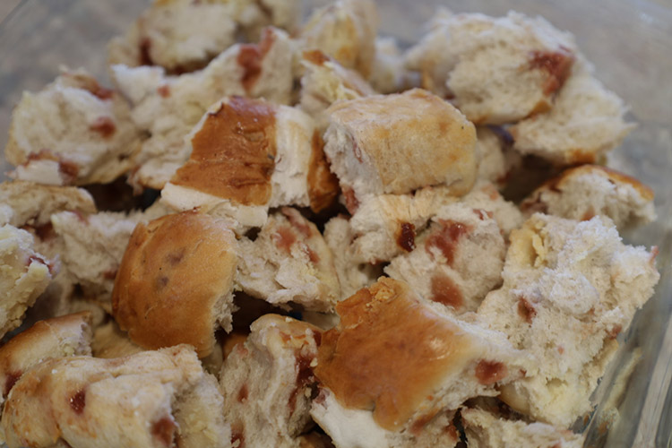 torn hot cross buns in a glass dish