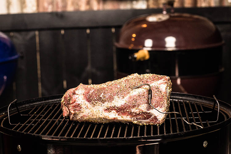 seasoned leg of lamb with internal meat probe on a smoker