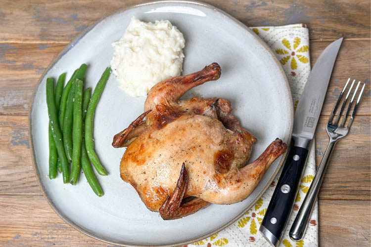 cornish hen plated with beans and mash