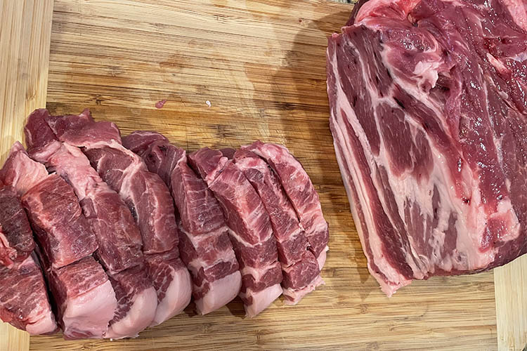 sliced pork butt on a wooden board
