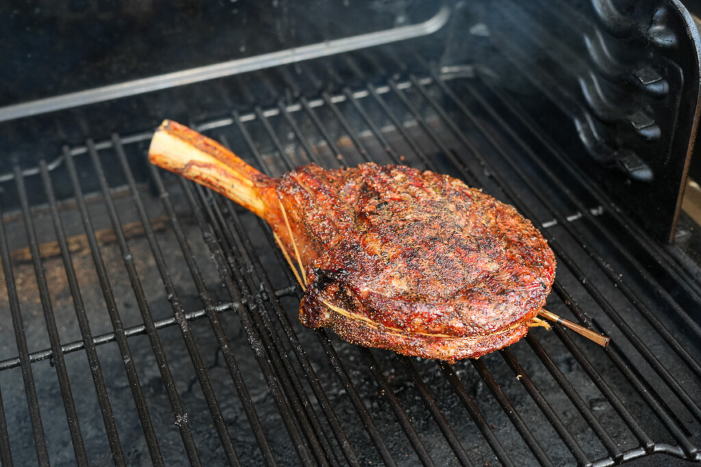 a tomahawk steak being reverse sear on the smoker