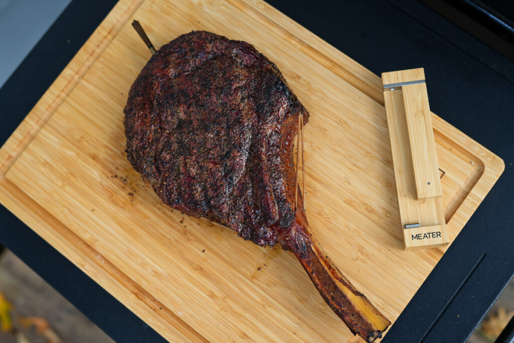 smoked tomahawk steak resting on a wooden board