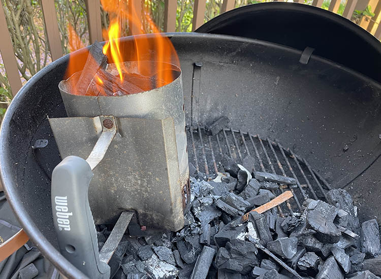 weber chimney starter full of lit charcoal