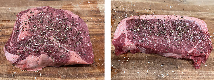 uncooked seasoned ribeye steak and NY strip steak on a wooden board