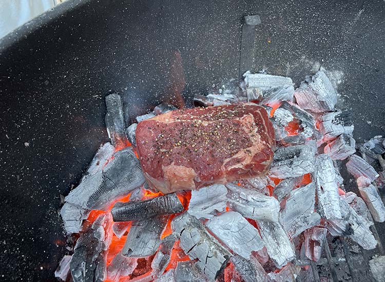 caveman ribeye steak on hot coals