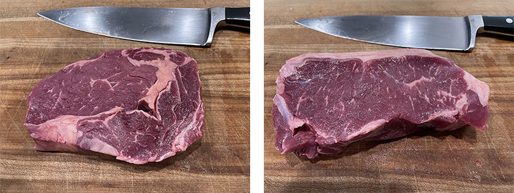 raw ribeye steak and NY strip steak on a wooden board