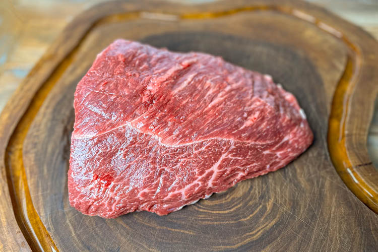 raw piece of rump cap on wooden board