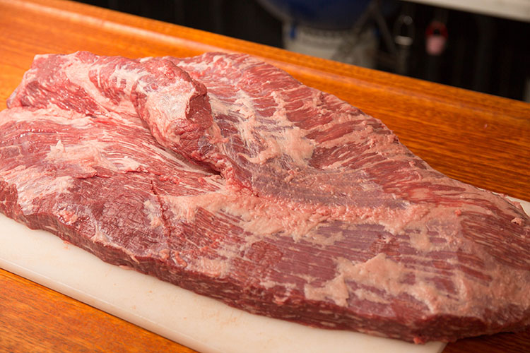trimmed beef brisket on a wooden board