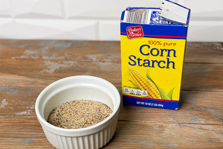 white ramekin with seasong and a box of corn starch on wooden bench