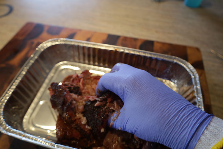 a man pulling smoked beef chuck
