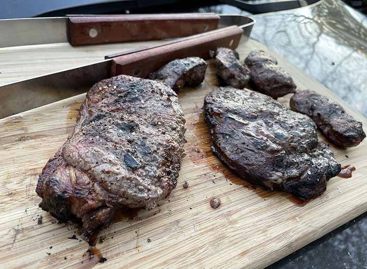 cooked steaks from silver fern farms on a wooden board