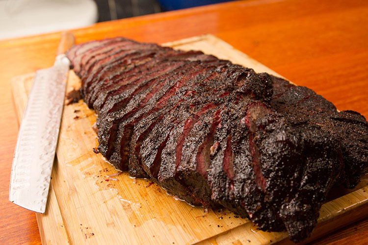 sliced hot and fast style brisket on a wooden board
