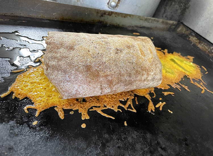 breakfast burrito and jalapeno cheese blanket on a griddle