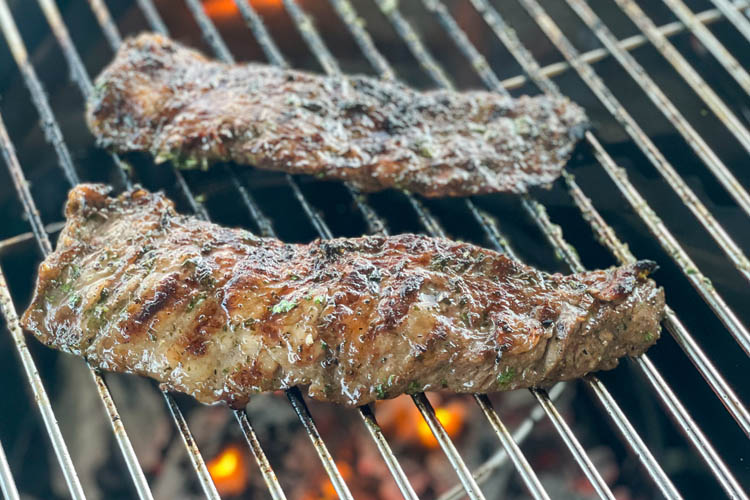 flank steak grilling on the smoker