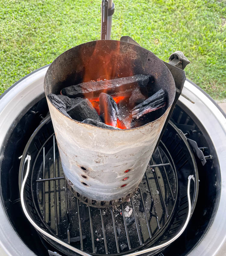 lit coals in a chimney starter on the smoker