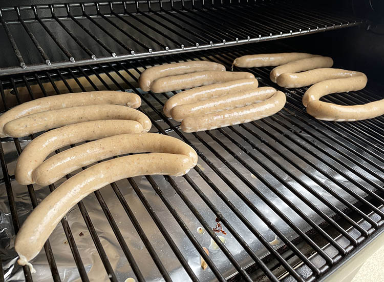 uncooked homemade hotdogs on a smoker